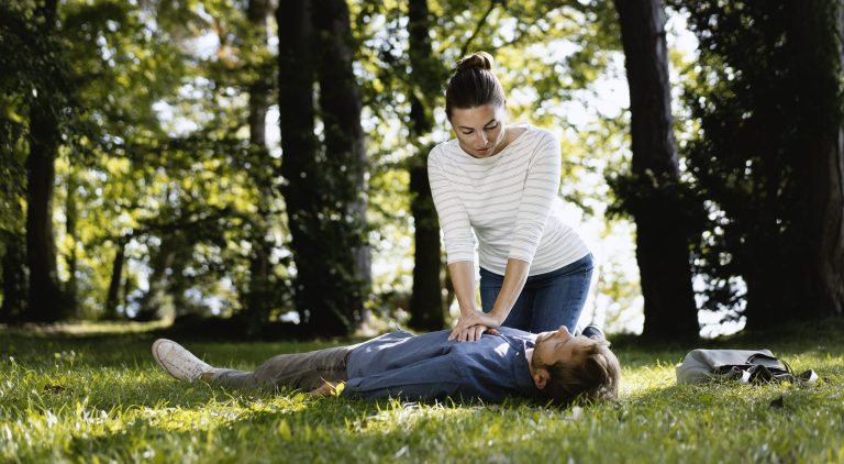Frau reanimiert leblosen Mann im Park