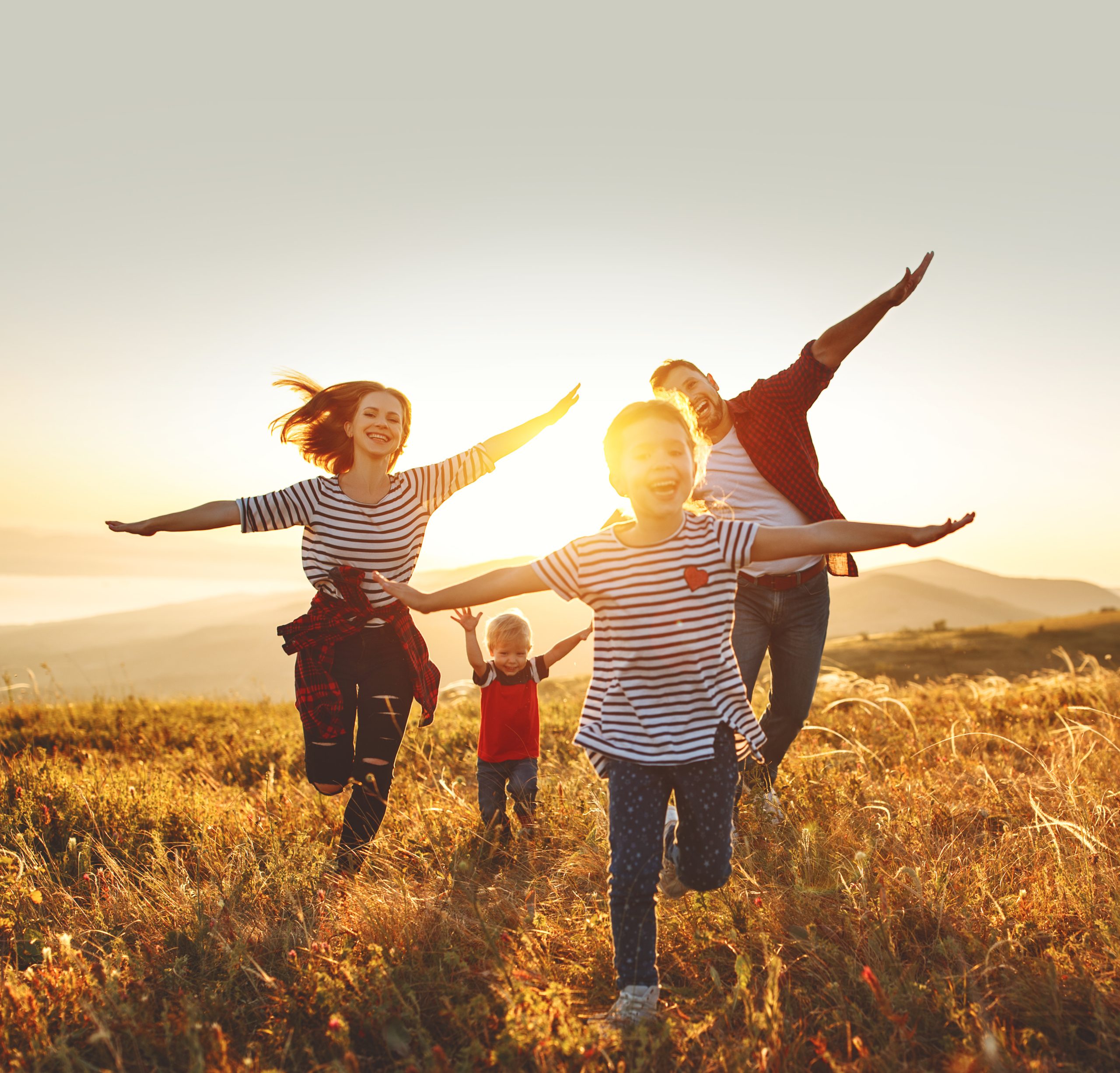 Familie läuft bei Sonnenuntergang auf einem Feld