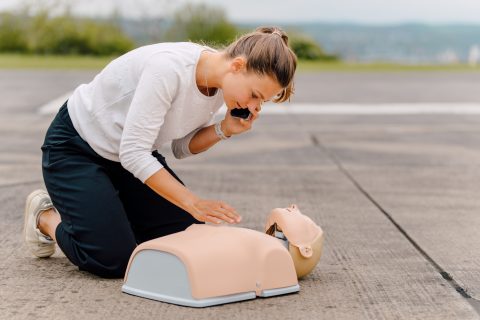 Frau übt Reanimation an einer Puppe