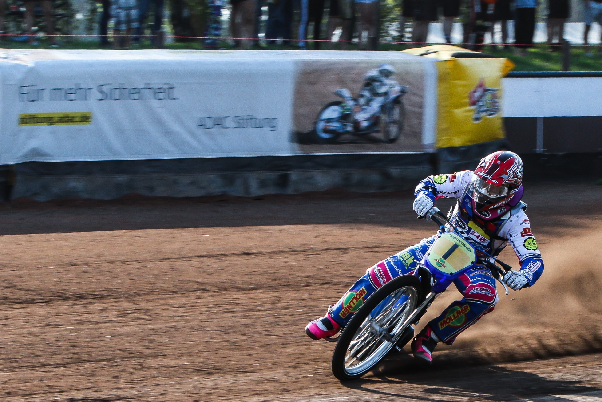 Bahnrennen Amateur-Motorsport, Ein Motorradfahrer. Im Hintergrund sind die Additional Protective Devices (APD) sichtbar, flexible luftgepolsterte Barrieren.