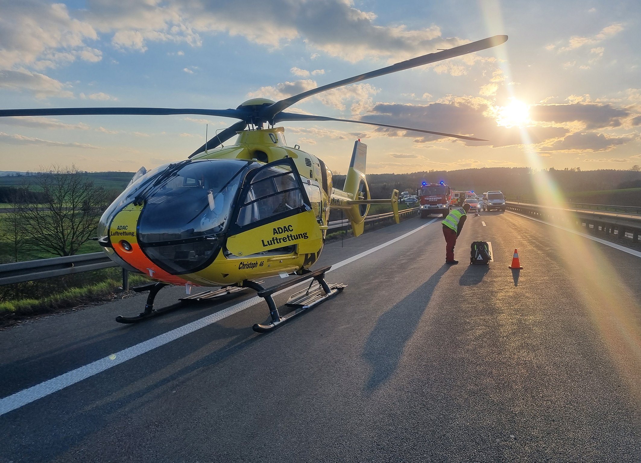 Hubschrauber der ADAC Luftrettung auf einer Autobahn, medizinisches Personal im Einsatz