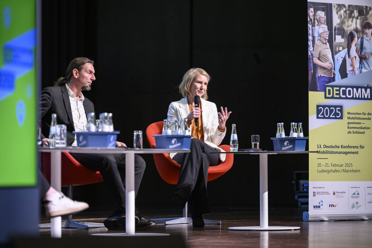 Bild mit Christina Tillmann auf der Bühne während der Podiumsdiskussion zur Eröffnung der DECOMM 2025